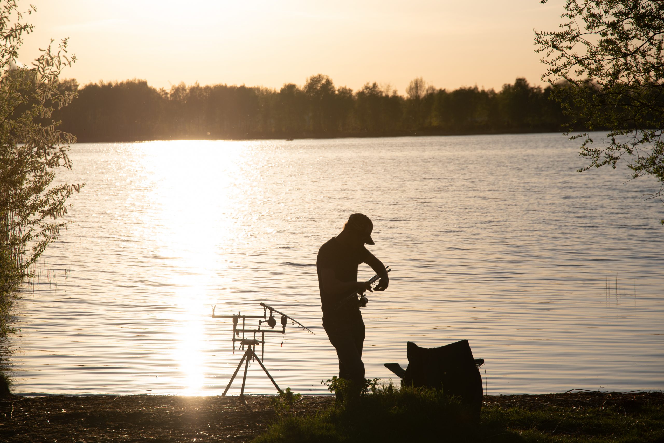 A fisherman silhouette fishing at sunset. Freshwater fishing, catch of fish